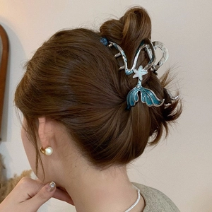 Elegant blue mermaid tail hair claw clip with star detail shown on model back view