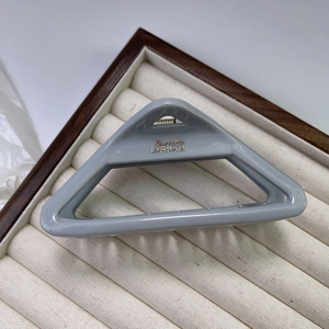 Close-up of a triangle shark hair claw in light blue with golden French lettering