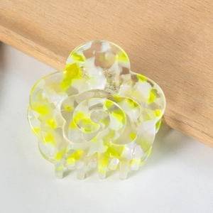 Close-up of hollow flower hair claw clip with yellow and white marble pattern design
