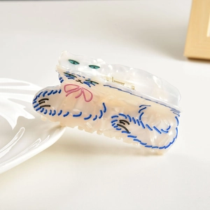 Détail de la pince à cheveux chat persan mignon en acétate crème et lignes bleues
