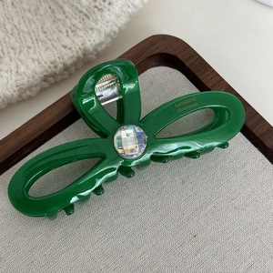 Détail d'une pince à cheveux vert vif en acétate ornée d'un cristal étincelant