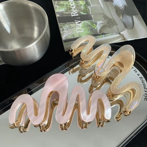 Grandes pinces à cheveux ondulées en acétate rose et beige avec un fini nacré élégant
