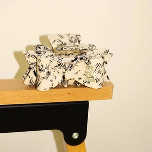 Detail of acetate marble hair claw with rhinestone bow and luxury sparkling accents
