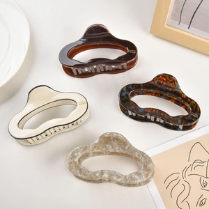 Detail view of four acetate hair claws in tortoise shell and marble patterns