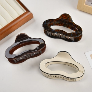 Detailed macro view showing tortoiseshell and cream acetate hair claw clips on display