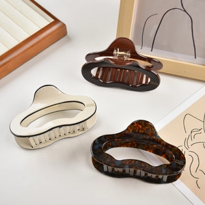 Three-piece set of large acetate hair claws in beige, dark brown, and tortoiseshell patterns