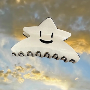 Pince à cheveux étoile en acétate crème avec motif smiley sur fond de ciel