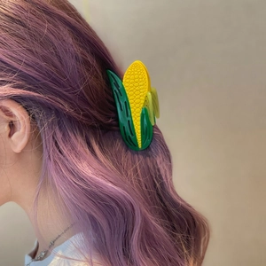 Realistic corn shaped hair claw clip in yellow and green on purple wavy hair