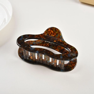 Detail of tortoise shell acetate hair claw clip with golden Amy Bear Handmade lettering