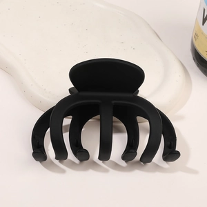 Grosse pince à cheveux crabe noir mat avec texture givrée sur support en céramique blanche