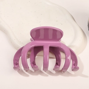Détail montrant la pince à cheveux pieuvre violette brillante sur un support blanc