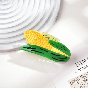 Macro shot of corn-shaped acetate hair claw with glossy yellow kernels and green leaves