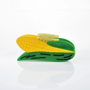 Detail of creative corn-shaped hair claw clip with yellow kernels and green leaf design