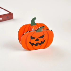 Gros plan d'une pince à cheveux citrouille d'Halloween en acrylique orange avec visage