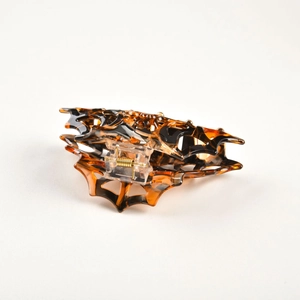 Detail of hollow spider web hair claw clip in classic leopard pattern with metal spring