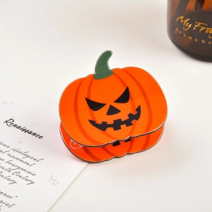 Gros plan d'une pince à cheveux citrouille d'Halloween avec visage de Jack-o'-lantern