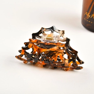 Detailed view of hollow wave pattern claw clip in classic tortoiseshell resin finish