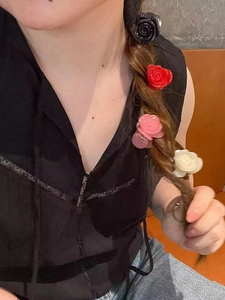 Detail showing four colors of mini rose hair claws styled on a braided ponytail