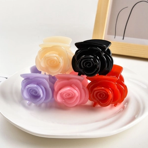 Detail of five jelly-colored rose hair claws in cream, black, purple, pink and red colors
