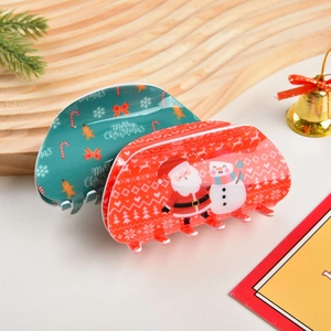 Dettaglio di pinze per capelli natalizie con motivi di pan di zenzero e Babbo Natale