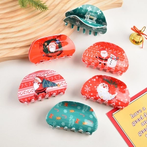 Dettaglio di vari fermacelli per capelli natalizi con motivi festivi di Babbo Natale