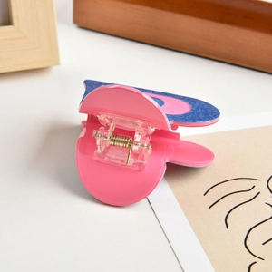 Detail showing the pink and navy blue heart hair claw clip with marble texture design