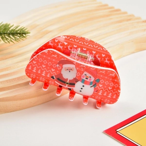 Dettaglio di un fermaglio per capelli natalizio rosso con motivi di Babbo Natale e pupazzo