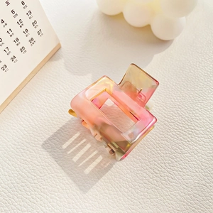 Detailed macro view of a rectangular hollow acetate hair claw with pink and orange marble texture