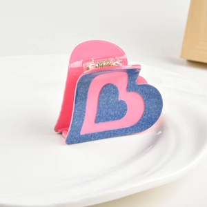 Detail of a pink and blue heart-shaped acetate claw clip with a glossy finish