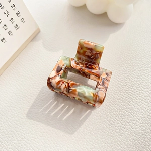 Detail view of square marble texture acetate hair claw clip with vintage amber pattern