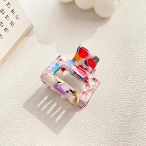 Macro detail of rectangle colorful acetate hair claw with vintage terrazzo pattern