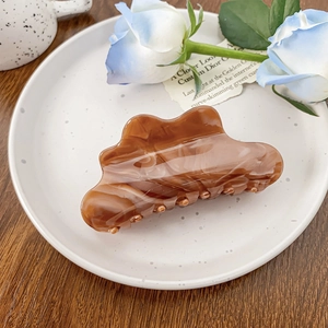Grande molletta per capelli in acetato ambrato su un vassoio decorativo