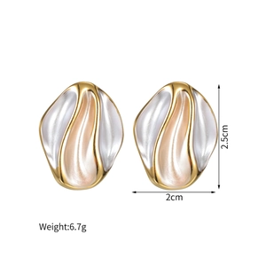 Detailed view showing 2.5cm by 2cm oval gold earrings with white enamel texture
