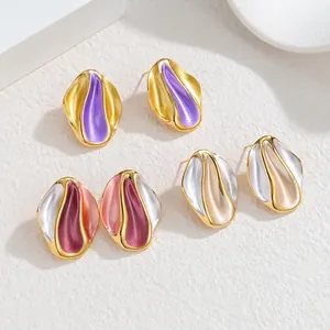 Irregular wavy gold trim earrings in purple, pink and white cream colors on white stone