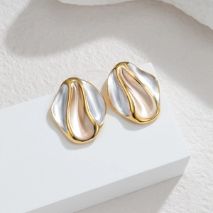 Detailed close-up of irregular wave earrings with gold edges and champagne enamel finish