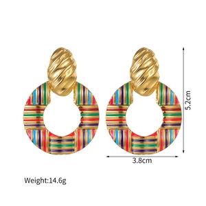 Gros plan de grandes boucles d'oreilles créoles rétro bohèmes avec rayures colorées