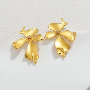 Vintage style matte gold flower earrings with sparkling central zircon on white pedestal
