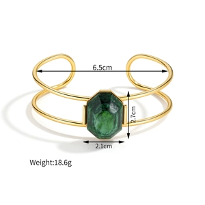 Detail of gold geometric cuff featuring a large green stone and precise dimensions