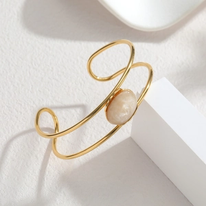 Elegant gold open cuff bracelet with parallel bands and an oval beige stone inlay