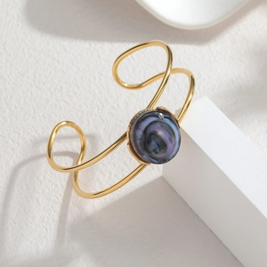Gold open cuff bracelet with vintage geometric design and purple blue stone centerpiece
