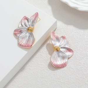 Pink and white gradient petal earrings with golden textured stamen on minimalist stand