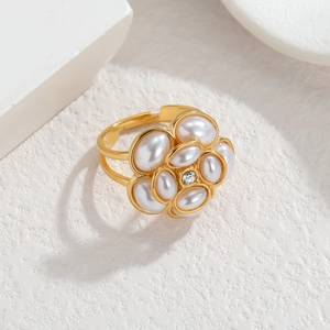 Vue détaillée d'une bague florale dorée avec perles blanches et un centre en cristal