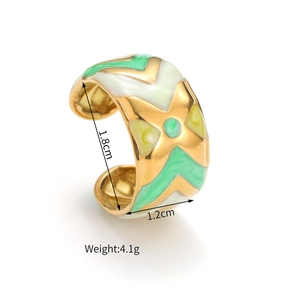 Detail view of colorful enamel wide band ring showing green white and yellow patterns