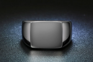 Detail of a polished flat top signet ring made of black stainless steel with a smooth surface