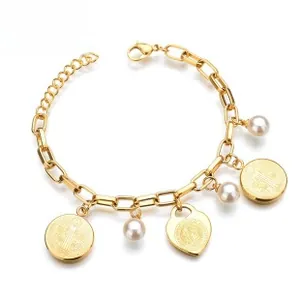 Detail of gold layered stainless steel bracelet with pearl, coin and heart charms
