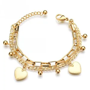 Detailed view of gold layered heart bracelet with curb and paperclip chains