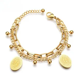 Detail of double-layer stainless steel gold bracelet with oval pendants and beads