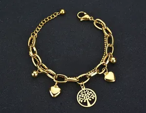 Detail of gold titanium double-layer bracelet with tree of life and heart pendants