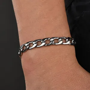 Close-up of polished stainless steel flat curb link bracelet worn on a wrist