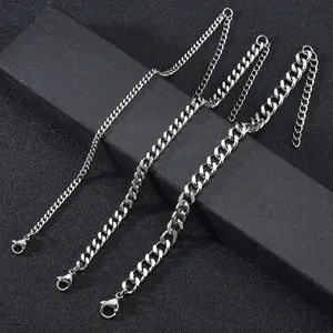 Three widths of silver stainless steel Cuban link chains with lobster clasps on black